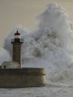 Büyük dalgalar deniz feneri günbatımı üzerinde