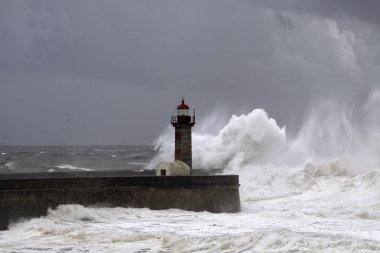 İskeleler ve deniz feneri fırtınalı dalgalar
