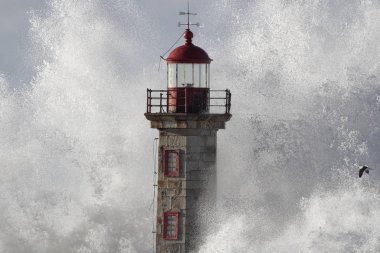 Bir büyük fırtınalı dalga sıçrama tarafından örtülü detaylı eski deniz feneri