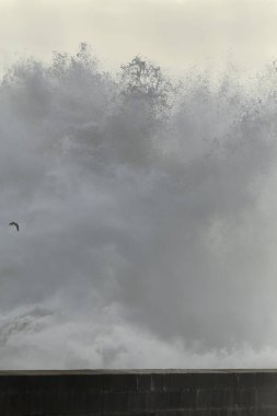 İskeleye karşı büyük dalga kırılıyor.