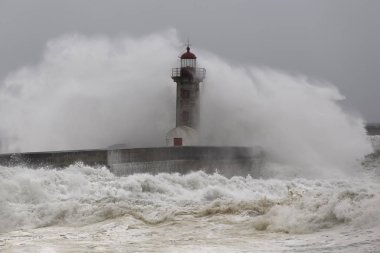 Büyük okyanus dalgası kazasından sonra rüzgar spreyi. Yaşlı Douro nehri ağzı deniz feneri ve iskele, Oporto.