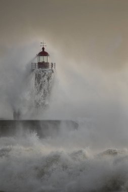 Douro Nehri 'nin ağzındaki eski deniz feneri fırtınada şiddetli dalgaların çarpmasından sonra akan suyu görüyor.