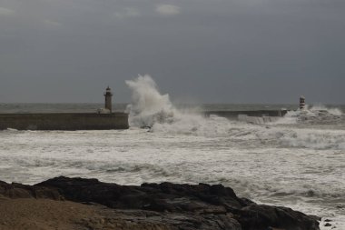 Yağmurlu bir gökyüzü ve fırtınalı bir deniz. Douro nehri ağzı, Porto, Portekiz.