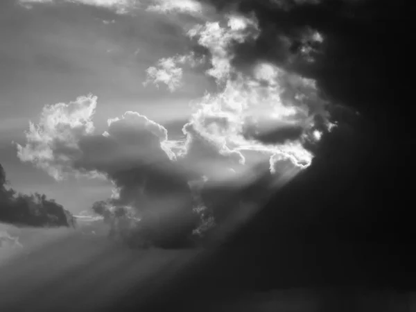 Black and white cloudy sky with sun rays. Used infrared filter.