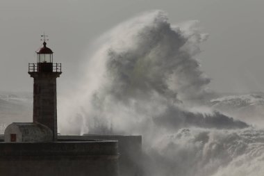 Büyük fırtınalı dalga sıçraması. Yaşlı Douro nehri ağzı deniz feneri ve iskele, Oporto.