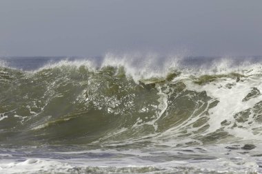 Büyük yeşil dalgalar mavi gökyüzüne karşı