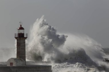 Büyük fırtınalı dalga sıçraması. Yaşlı Douro nehri ağzı deniz feneri ve iskele, Oporto.