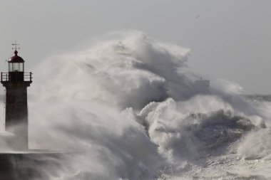 Büyük fırtınalı deniz dalgası sıçraması. Douro nehri ağzı rıhtımları ve deniz fenerleri.