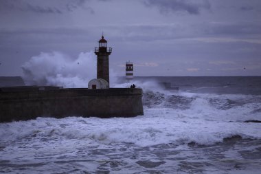 Alacakaranlıkta dramatik deniz manzarası. Douro Nehri, bir deniz fırtınası sırasında kuzey rıhtımlarını ve fenerleri mırıldanır..