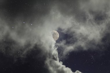 Dolunay gecesi, yıldızlar ve bulutlar.