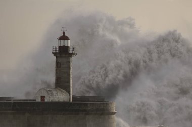 Büyük dalga, Douro nehrinin ağzına sıçrıyor. Eski deniz feneri, Oporto.