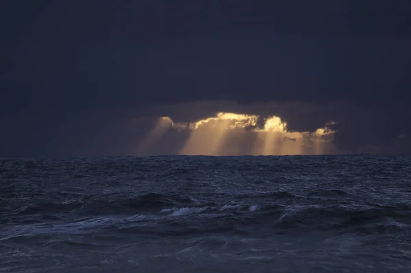 Turuncu Güneş Işınlarıyla Fırtınalı Koyu Mavi Gün Batımı — Stok fotoğraf