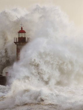 Fırtınalı büyük dalgalar Douro nehrinin üzerine sıçrıyor. Eski deniz feneri ve iskele.