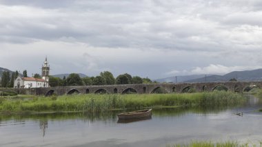 Yağmurlu bir günde, Portekiz 'in kuzeyinde, Ponte de Lima Ortaçağ' dan kalma eski granit köprü ve kilise.