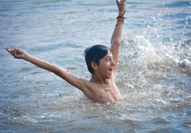 TIKAMGARH, MADHYA PRADESH, INDIA - 13 Kasım 2019: Kimliği belirsiz Hint köylü çocuk tatlı nehir suyunda yüzüyor.