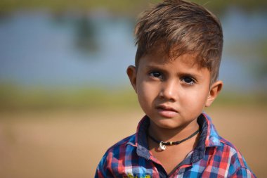 Tikamgarh, Madhya Pradesh, Hindistan - 20 Kasım 2019: Açık havada ifade eden mutlu küçük Hintli çocuk.