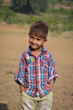 Tikamgarh, Madhya Pradesh, Hindistan - 20 Kasım 2019: Açık havada ifade eden mutlu küçük Hintli çocuk.