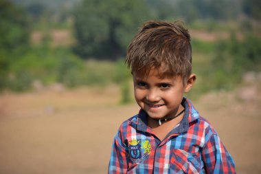 Tikamgarh, Madhya Pradesh, Hindistan - 20 Kasım 2019: Açık havada ifade eden mutlu küçük Hintli çocuk.