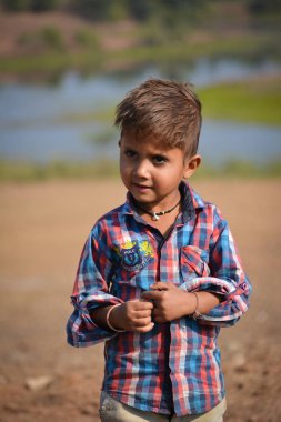 Tikamgarh, Madhya Pradesh, Hindistan - 20 Kasım 2019: Açık havada ifade eden mutlu küçük Hintli çocuk.