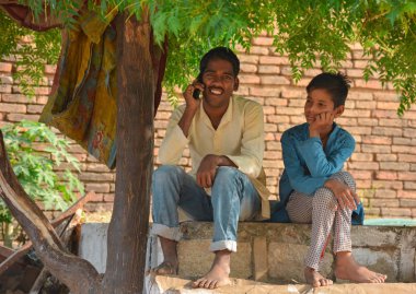 Tikamgarh, Madhya Pradesh, Hindistan - 15 Kasım 2019: Cep telefonuyla konuşan Hintli köylü çocuk.