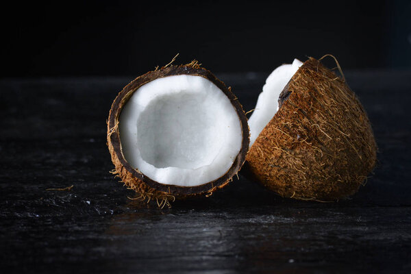 Coconut with half on a dark background. Organic healthy food concept.