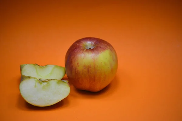 Jabłko Plastrami Pomarańczowym Tle — Zdjęcie stockowe