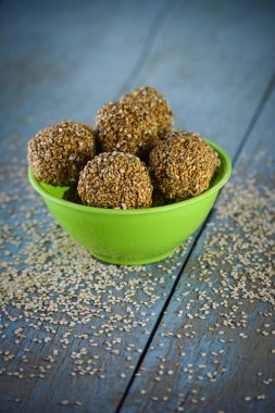 Tahta arka planda kasede susam laddu.