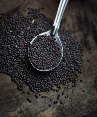 Tahta bir masada kara hardal tohumları.