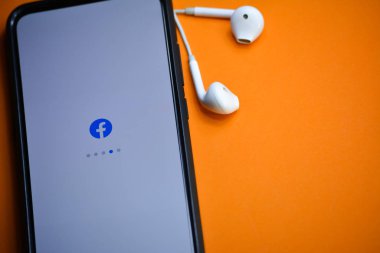 Tikamgarh, Madhya Pradesh, Hindistan - 17 Aralık 2019: Kulaklıkla cep telefonu ekranına yüklenen Facebook uygulaması. Facebook dünyadaki en büyük ve en popüler sosyal ağ sitesidir.