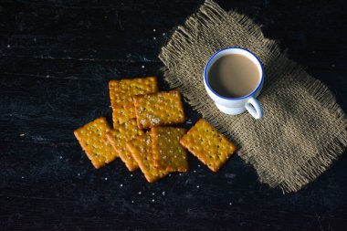 Eski ahşap arka planda bisküvili bir fincan çay.