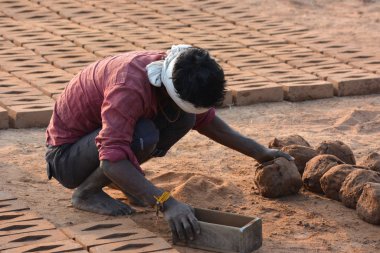 Tikamgarh, Madhya Pradesh, Hindistan - 07 Şubat 2020: Kimliği belirlenemeyen Hintli adam ev tuğlaları yapıyor..