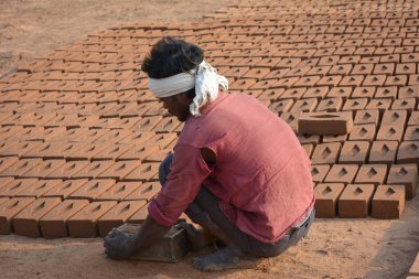 Tikamgarh, Madhya Pradesh, Hindistan - 07 Şubat 2020: Kimliği belirlenemeyen Hintli adam ev tuğlaları yapıyor..