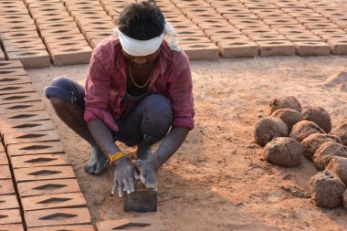 Tikamgarh, Madhya Pradesh, Hindistan - 07 Şubat 2020: Kimliği belirlenemeyen Hintli adam ev tuğlaları yapıyor..
