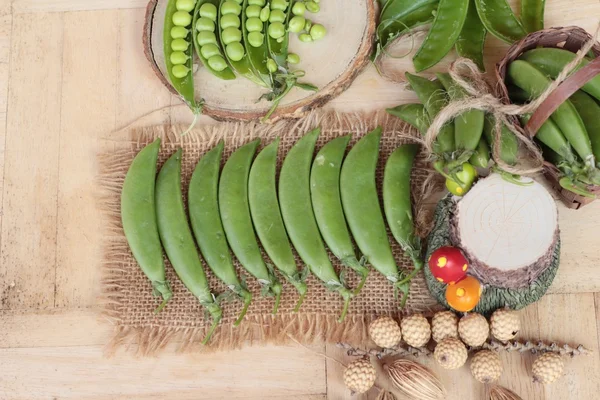 Vaina de guisantes verdes frescos sobre fondo de madera — Foto de Stock