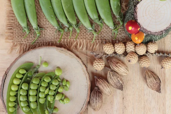 Vaina de guisantes verdes frescos sobre fondo de madera — Foto de Stock