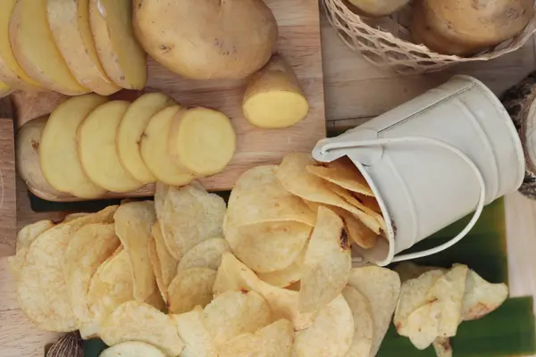 Crispy potato chips with salt and fresh potatoes — Stock Photo, Image