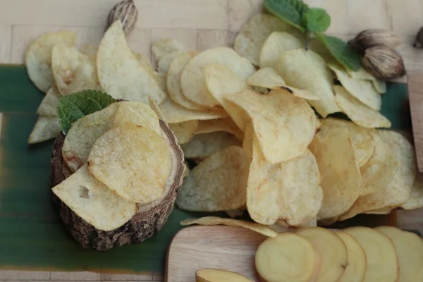 Crispy potato chips with salt and fresh potatoes — Stock Photo, Image