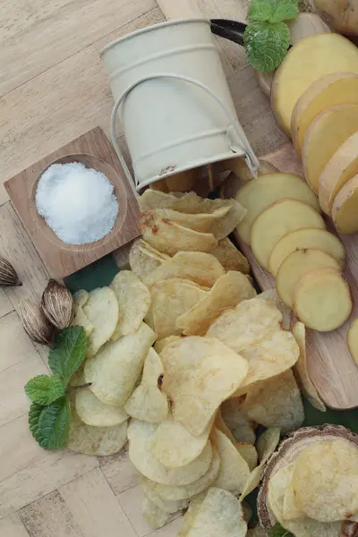 Crispy potato chips with salt and fresh potatoes — Stock Photo, Image