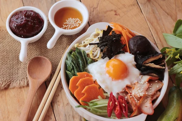 La nourriture coréenne Bibimbap est délicieuse sur fond de bois — Photo