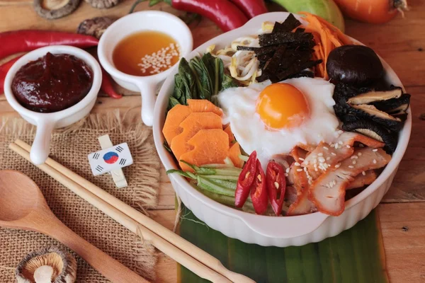Ahşap arka plan üzerinde Bibimbap Kore gıda lezzetlidir — Stok fotoğraf
