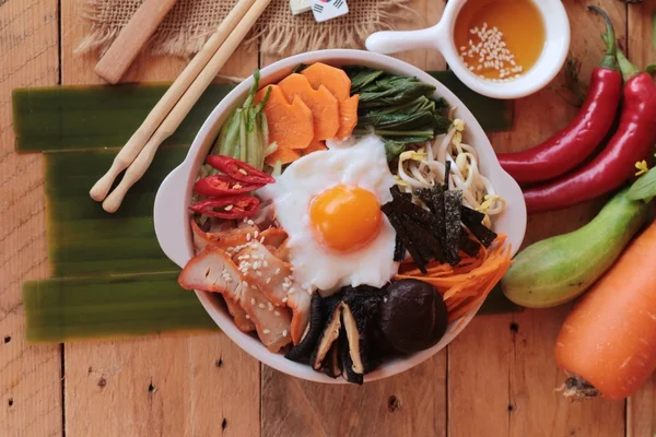 Bibimbap comida coreana es delicioso sobre fondo de madera —  Fotos de Stock