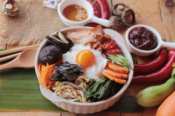 Bibimbap comida coreana é deliciosa no fundo de madeira — Fotografia de Stock