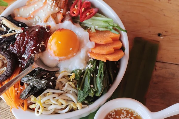 Bibimbap comida coreana es delicioso sobre fondo de madera — Foto de Stock