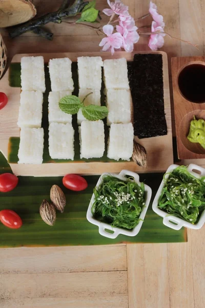 Membuat sushi gulung dan salad rumput laut dengan nasi — Stok Foto