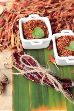 Biber tozu ve ahşap arka plan üzerinde kurutulmuş biber