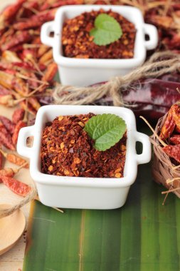 Biber tozu ve ahşap arka plan üzerinde kurutulmuş biber