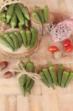 Taze bamya bakla ve ahşap zemin üzerine dilimlenmiş