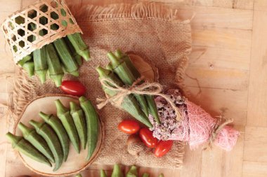 Taze bamya bakla ve ahşap zemin üzerine dilimlenmiş