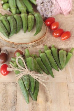 Taze bamya bakla ve ahşap zemin üzerine dilimlenmiş