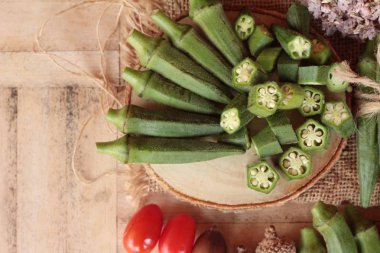 Taze bamya bakla ve ahşap zemin üzerine dilimlenmiş